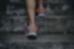 person wearing orange and gray Nike shoes walking on gray concrete stairs_edited.jpg