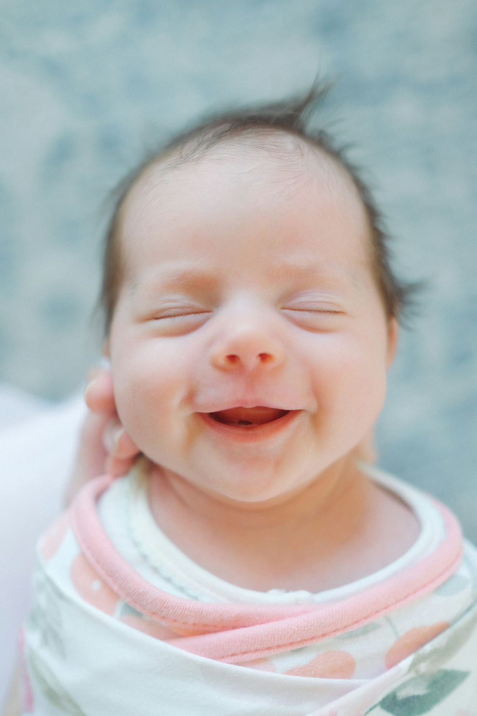 A sleeping baby grins widely