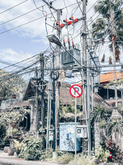 Worker on electrical pole in urban setting.