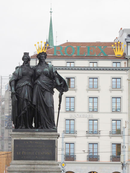 Two statues in front of a historic building.