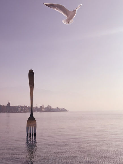 Fork sculpture in water with misty background.