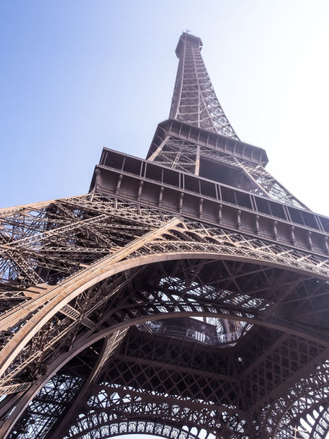Eiffel Tower viewed from below against clear sky.