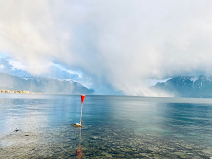 Calm lake with misty mountains in the background.
