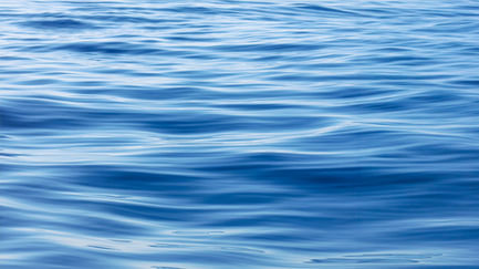 Blue rippling water surface texture, close-up view.