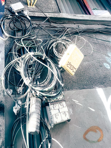 Tangled cables and wires on a utility pole.