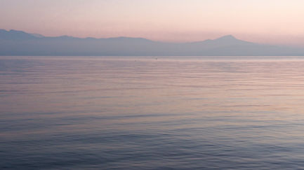 Calm sea with a soft pink horizon.
