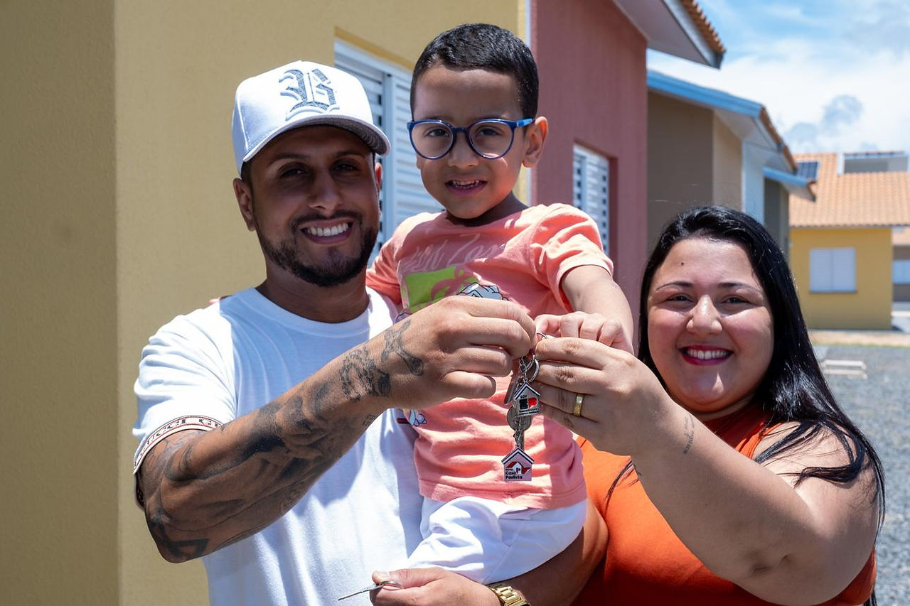 foto de uma família segurando uma chave de uma casa 