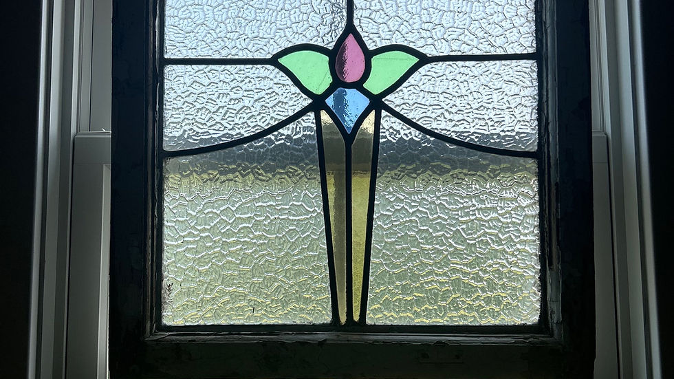 A stained glass window hung as a decorative accent providing colored light.