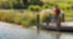 A father and young son are fishing on a dock over a pond in the Willowsford community in Aldie, Virginia.