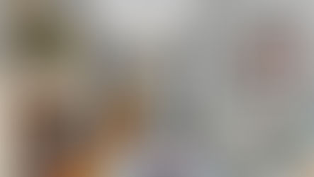 Living room in the Parran House with a wood-burning fireplace, tall windows, and original hardwood floors