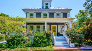 Front exterior of 15520 Second Street, a 1918 American Foursquare with wrap-around porch and yellow front door in the Village of Waterford, Virginia