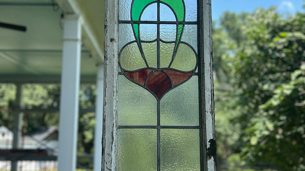 An old stained glass window hung as an outdoor ornament.