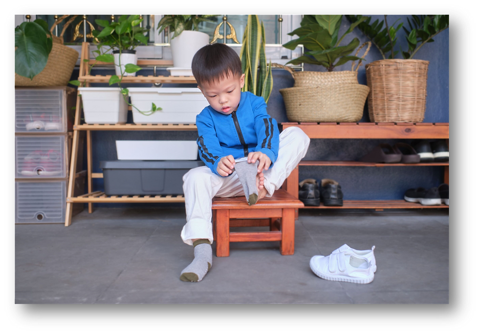 A child trying to be independent and wear shoes as a part of school readiness