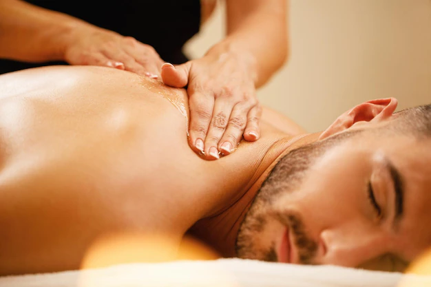 closeup-man-enjoying-relaxing-back-massage-with-honey-spa_637285-2262.webp
