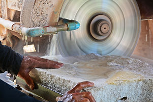 close up hand of stone mason cutting san