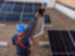 Equipo de técnicos montando paneles solares en techo industrial