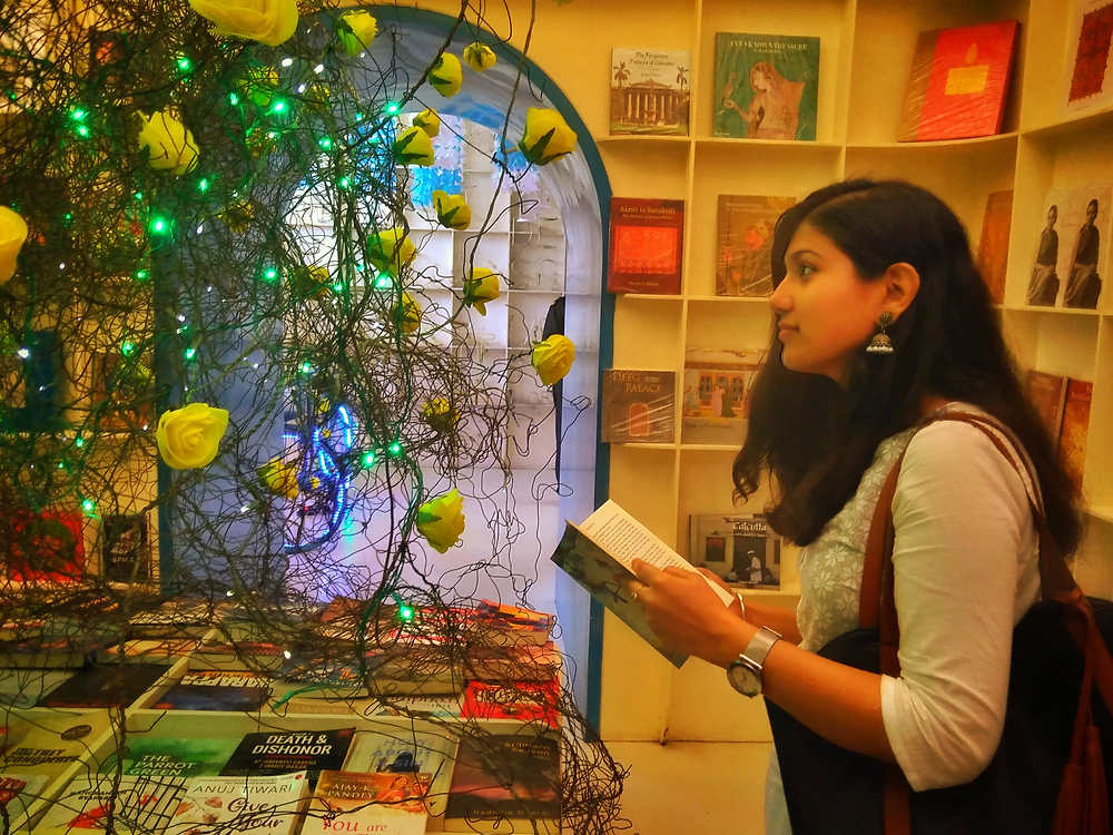 Girl at a bookstore / library with a book thinking
