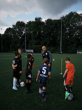 Afbeelding van coach en jeugdspeler: "Coach helpt jonge voetballer bij fysieke en mentale training bij PlayBetter