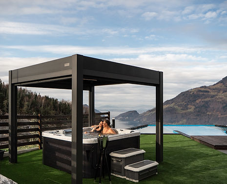 Couple relaxing in private open-sky whirlpool with lake and mountain view – Villa Tauris Switzerland
