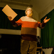 Someone reading a story aloud, on stage