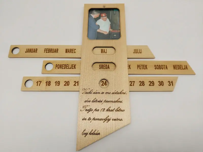 Leseni večni koledar. S premikanjem letvic nastavimo datum. Vložite svojo poljubno fotografijo. Spodaj tekst po izbiri.