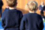 two 12 year old children playing shown from behind wearing dark blue jumpers.jpg