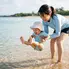 海水浴デビューで波打ち際に足をつける1歳の子どもとママ