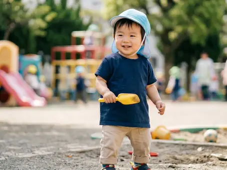 保育園の園庭で楽しそうに遊ぶ一歳の子供