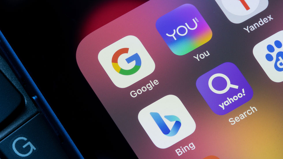 Close-up of smartphone screen showing search engine app icons: Google, You, Yandex, Bing, Yahoo. Colorful, with a keyboard edge visible.