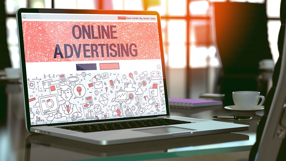 Laptop on a desk displaying "Online Advertising" with red graphics. Sunlight streams through windows, casting a warm glow on a coffee cup.