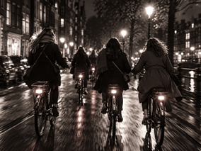 Black and white photo of women on bicycles seen from behind during a march for equal rights
