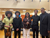 A group of 5 BSU students smiling holding their instruments post-concert