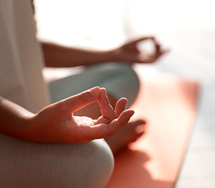 close des mains en mudra d'une personne qui médite sur un tapis de yoga