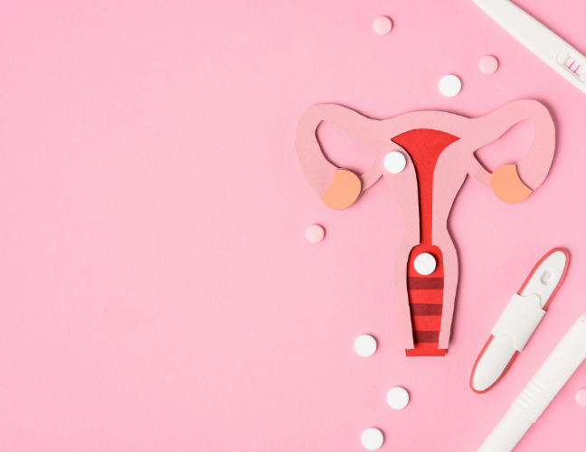 Pink background with a cartoon uterus and pregnancy tests