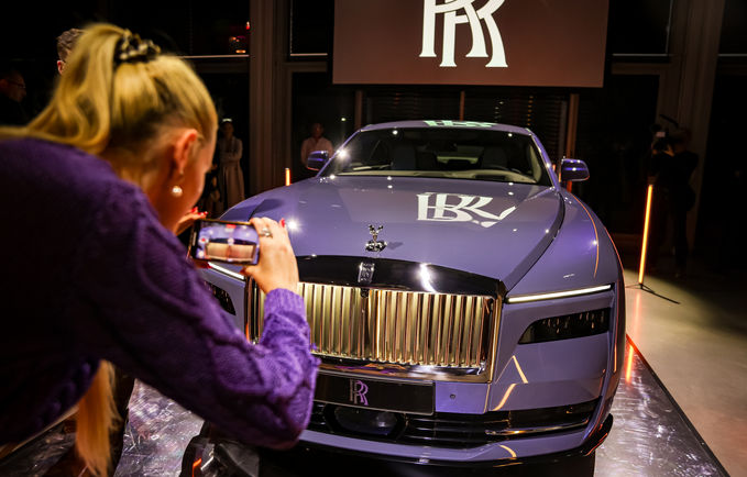 Eine Frau fotografiert bei der Vorstellung des neuen, elektrischen Rolls Royce das Auto