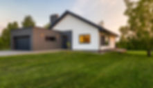 a modern home and garage with manicured lawn