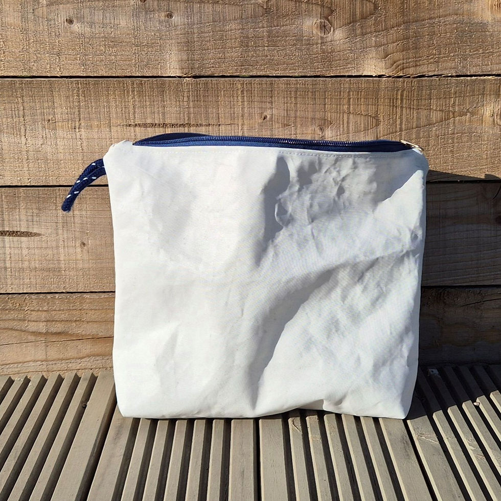 Thumbnail: White Toiletry Bag with blue zip and original features on wooden decking in front of a fence