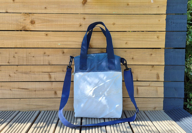 Finished bag made of blue and white Sail leaning against fence on decking
