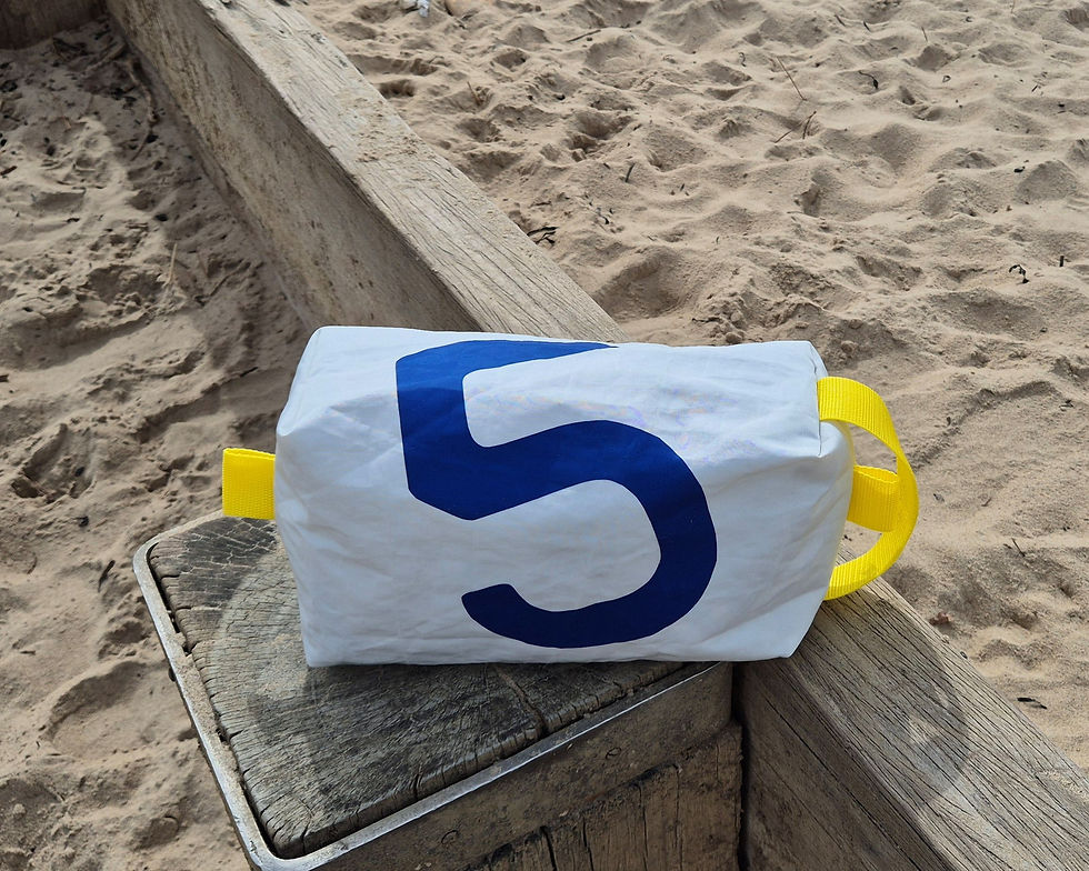 White Sailcloth bag. Yellow handle on one side, nautical no. 5 and blue zip on top