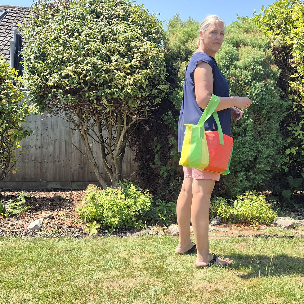 Thumbnail: Person in a garden setting with Yellow Green Pink striped Bag with light green handles and green zip on top