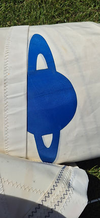 Saturn symbol on a white sail, some original stitching also visible