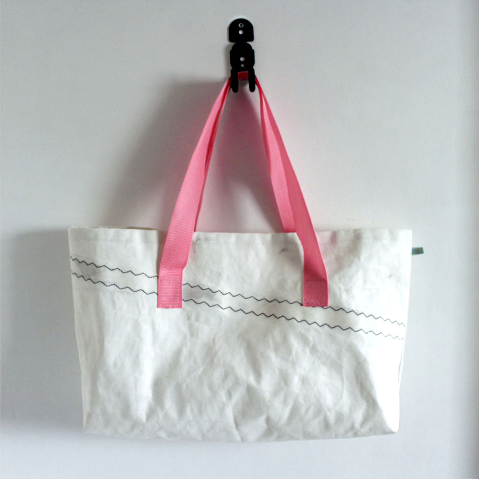 White Sail bag with pink handles. hanging from black hook on white background-