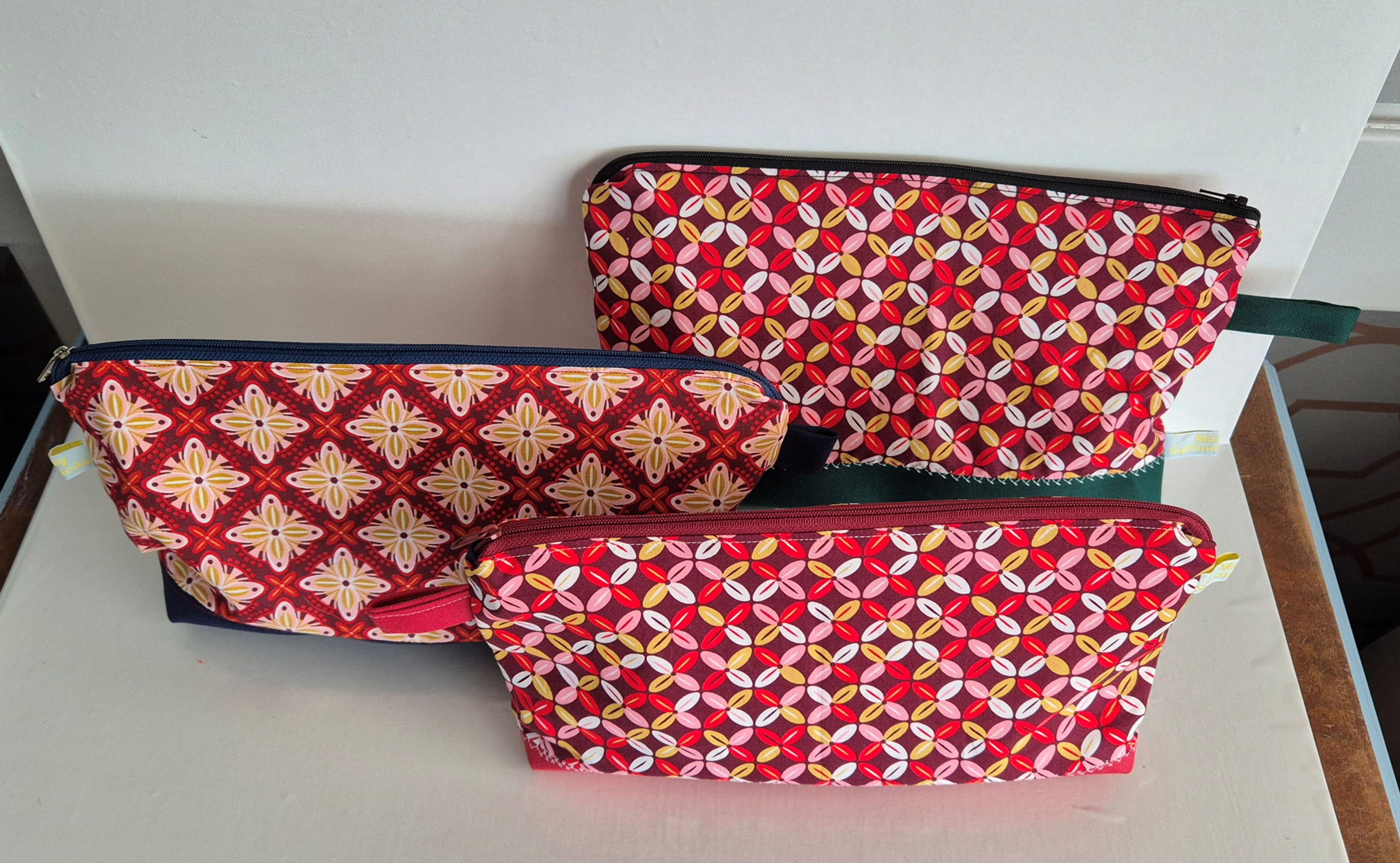 three cosmetic pouches on white background