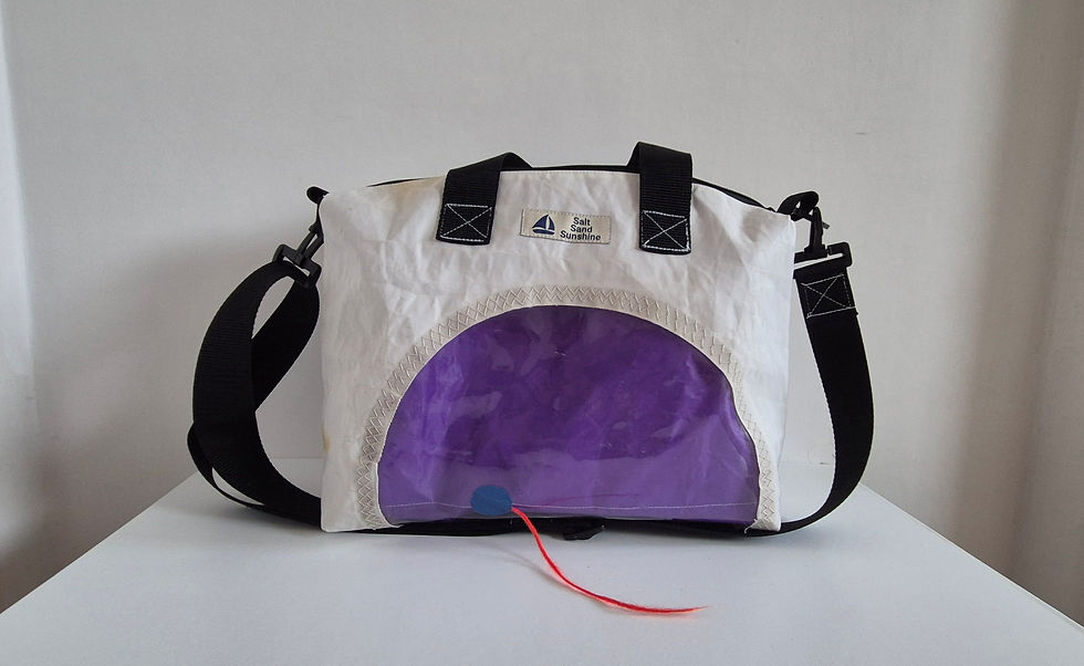 Thumbnail: White horizontally sail bag with black handles, black crossbody strap and black zip, purple interior visible