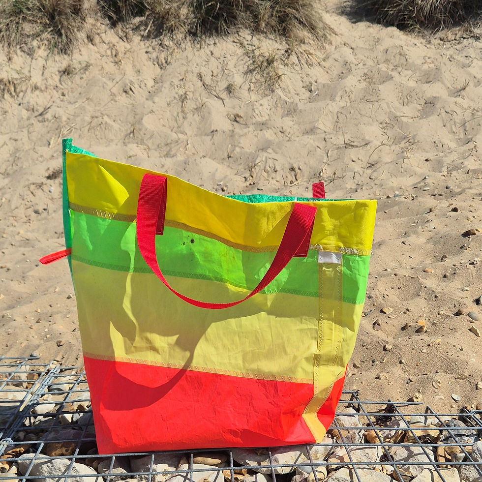 Large Shoulder Bag made of Pink, yellow green striped horizontally sailcloth. Red handles are hanging down.