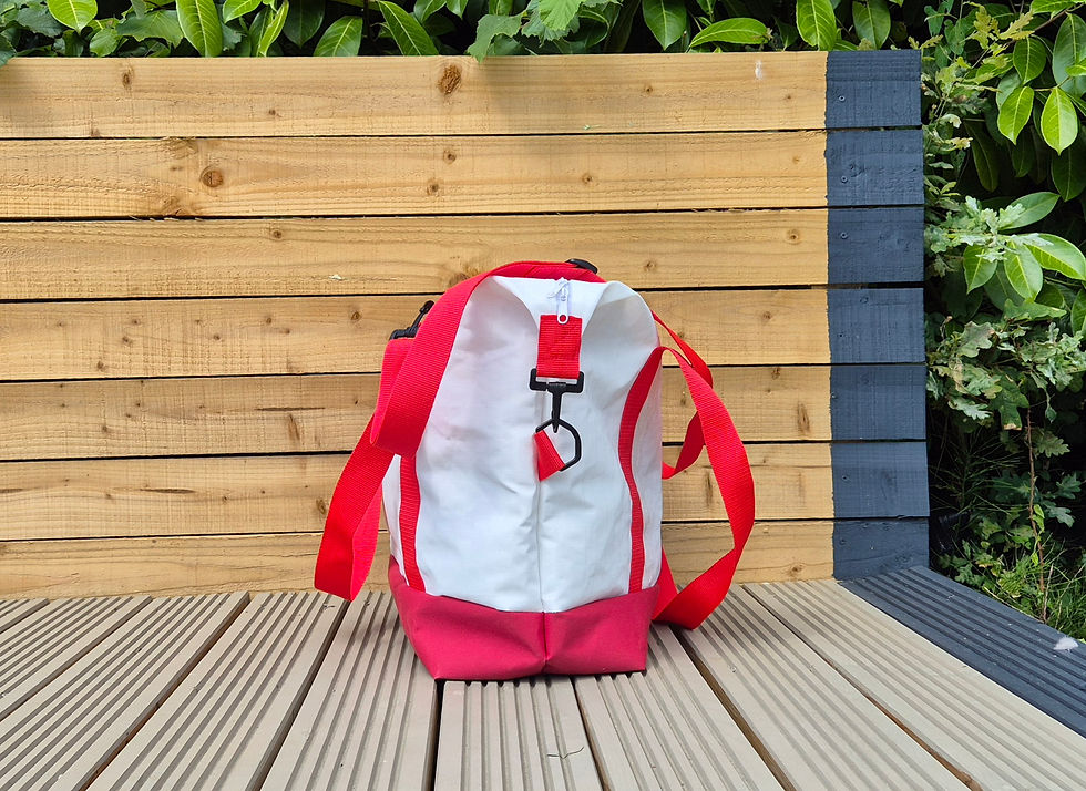 Thumbnail: White Sail Bag with red handles and red canvas flooring, black hook, outside setting