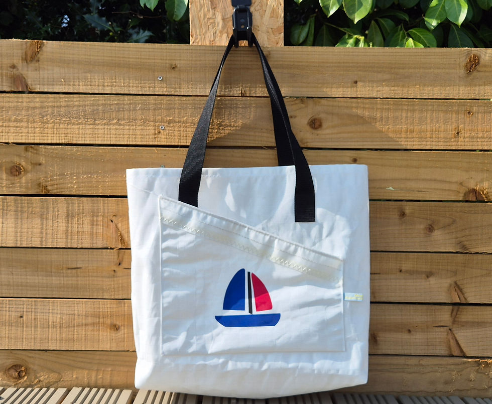 White Sail bag with black handles and boat application in front of a fence