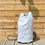 Thumbnail: White Duffel Bag with original blue stitching and blue Rope. Garden setting