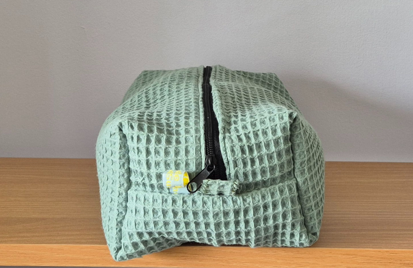 Green Waffle Cotton Fabric Pouch with black Zip from the side.