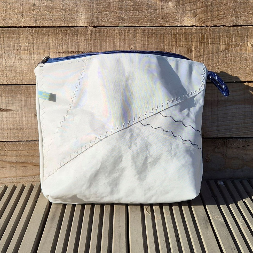 Thumbnail: White Toiletry Bag with blue zip and original features on wooden decking in front of a fence